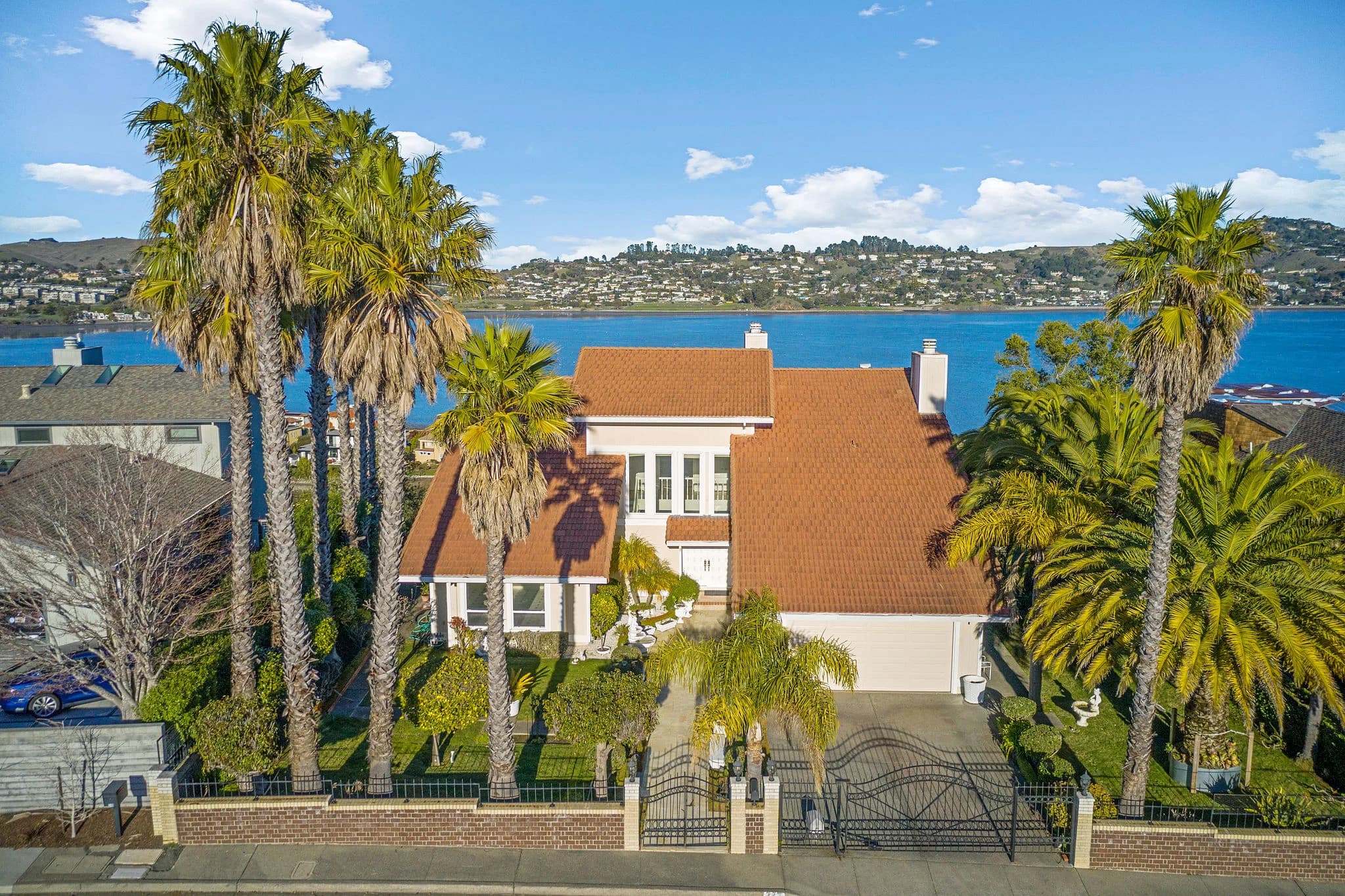 142 Great Circle Drive exterior framed by palms, with the Bay behind the home