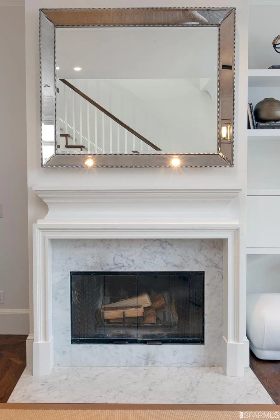 Wood-burning fireplace with a marble surround and mirrored overmantel