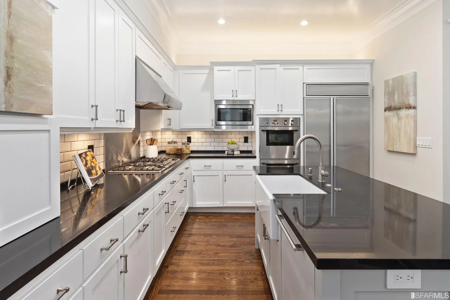 Updated white kitchen with stone counters and stainless-steel appliances