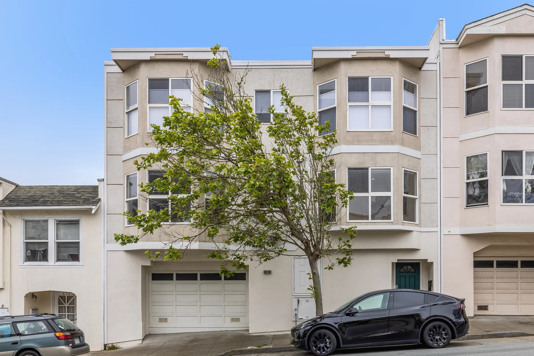 Street-facing building exterior at 688 25th Avenue with bay windows and a sidewalk tree