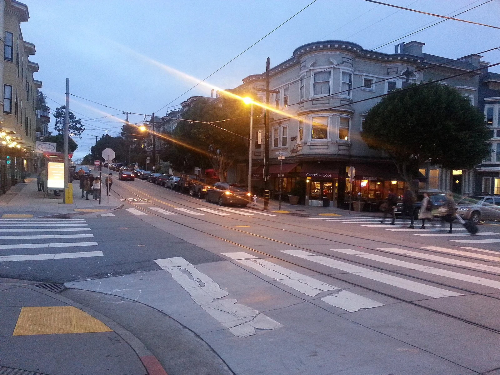 The corner of Carl and Cole Streets at twilight.